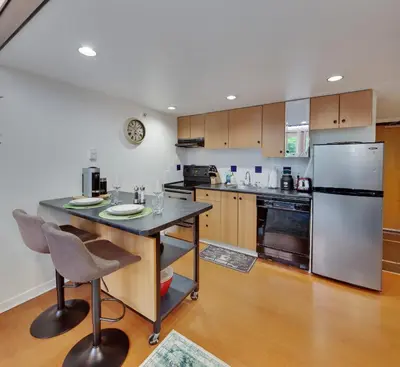a kitchen with a refrigerator and a table with chairs at Stylish Two-Story Loft with Rooftop Deck in Vancouver