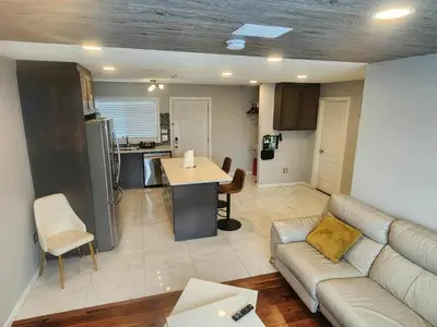 a living room with a couch and a kitchen at Modern Family Home with guest heat garage, Pet-Friendly!- NO BASEMENT in Edmonton
