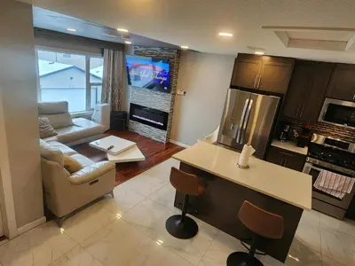 a kitchen and living room with a couch and a table at Modern Family Home with guest heat garage, Pet-Friendly!- NO BASEMENT in Edmonton