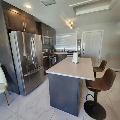 a kitchen with a counter and a refrigerator at Modern Family Home with guest heat garage, Pet-Friendly!- NO BASEMENT in Edmonton