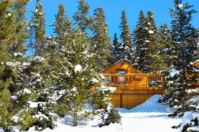 a log cabin in the woods in the snow at Mount Engadine Lodge in Kananaskis Village