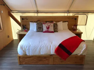 a bedroom with a large bed in a tent at Mount Engadine Lodge in Kananaskis Village