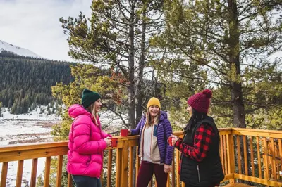 a group of three women standing on a wooden fence at Mount Engadine Lodge in Kananaskis Village