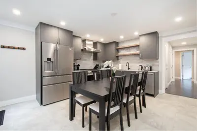 a kitchen with a black table and black chairs at Elegant and Roomy Forest Getaway in North Vancouver
