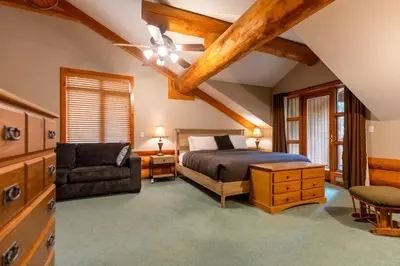 a bedroom with a bed and a chair at Alders Chalet by Fernie Central Reservations in Fernie