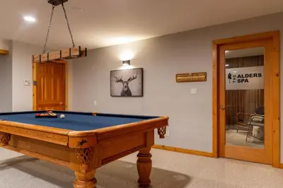 a room with a pool table in a room with a door at Alders Chalet by Fernie Central Reservations in Fernie