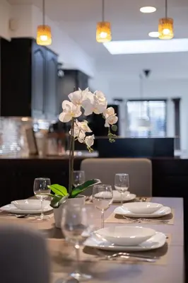 a table with plates and glasses and a flower on it at 3BR Near Commercial Dr 10 min to Downtown in Vancouver