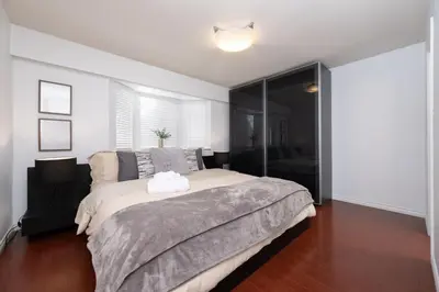 a bedroom with a bed and a sliding glass door at 3BR Near Commercial Dr 10 min to Downtown in Vancouver