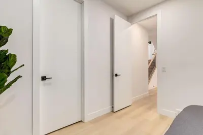 a bedroom with white walls and white doors at Perfect for Long Stays Free Parking Pets Allowed in Calgary