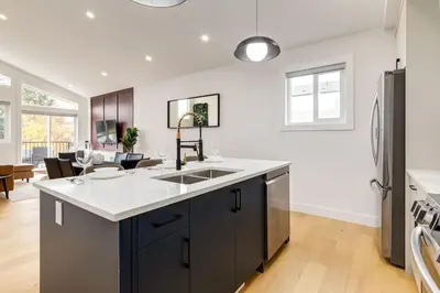 a kitchen with a sink and a refrigerator at Perfect for Long Stays Free Parking Pets Allowed in Calgary