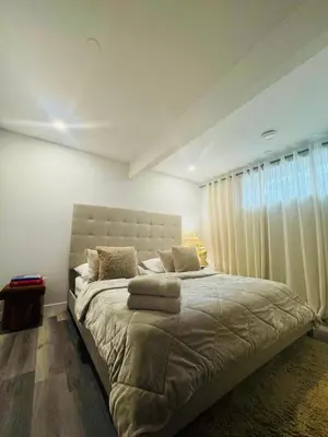 a bedroom with a large bed with a large window at Comfy Neutral Living Free Parking in Calgary