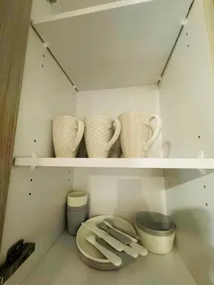 a shelf with three cups and plates and bowls at Comfy Neutral Living Free Parking in Calgary