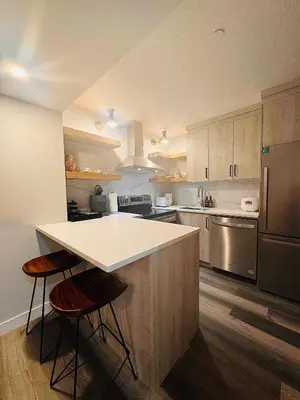 a kitchen with a counter and two stools at Comfy Neutral Living Free Parking in Calgary