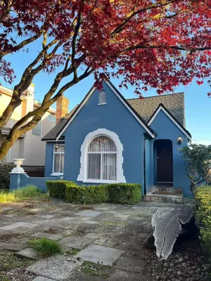 a blue house with a tree in front of it at Elmshade Villa in Vancouver South in Vancouver