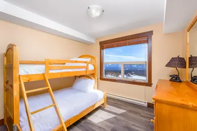 a bedroom with bunk beds and a desk with a window at Stonegate Resort Unit C105 in Kelowna