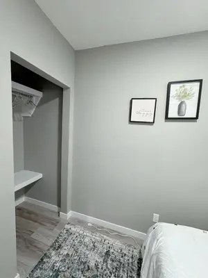a white bedroom with two pictures on the wall at 2 Bedroom Basement Suite in Edmonton