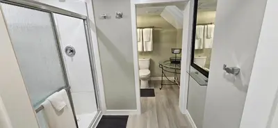 a white bathroom with a shower and a toilet at 1 block to Kelowna General Hospital 2 blocks to Beach 1km to OUC 1km to Downtown Kelowna 20min to YLW in Kelowna