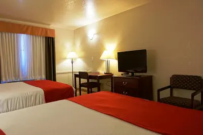 a hotel room with two beds and a flat screen tv at Gold Circle Inn in Lloydminster