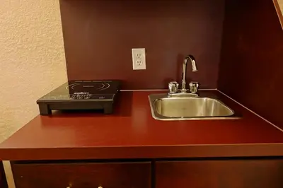 a kitchen counter with a sink and a stove at Gold Circle Inn in Lloydminster
