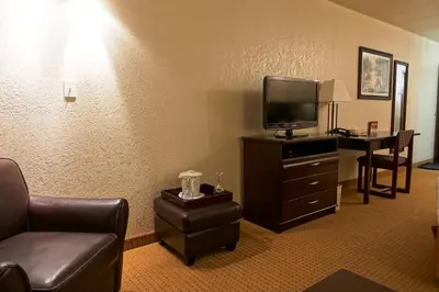 a hotel room with a couch and a tv and a table at Gold Circle Inn in Lloydminster