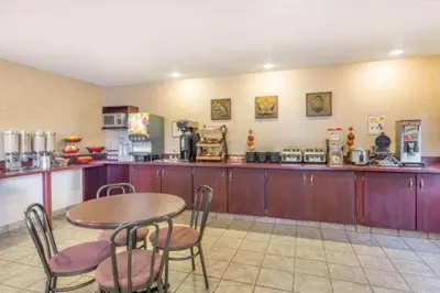 a restaurant with a table and chairs and a kitchen at Gold Circle Inn in Lloydminster