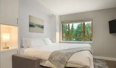a white bedroom with a bed and a window at KING Bed STUDIO in the Village in Whistler