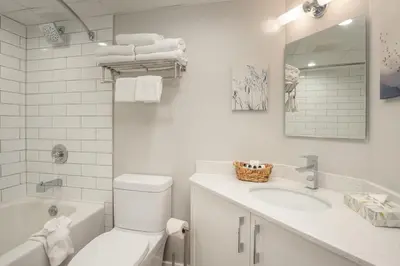 a white bathroom with a toilet and a sink at KING Bed STUDIO in the Village in Whistler