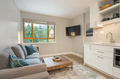 a living room with a couch and a table at KING Bed STUDIO in the Village in Whistler