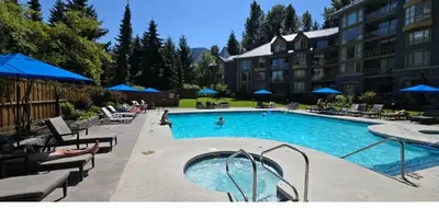 a large swimming pool in a hotel with people in it at KING Bed STUDIO in the Village in Whistler