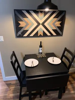 a black table with two chairs and a bottle of wine at Licensed 2-Bedroom Suite Eco-Friendly Solar Home in Kelowna