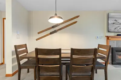 a dining room with a wooden table and chairs at Nicklaus North - Clubhouse by Whistler Premier in Whistler