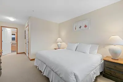 a bedroom with a large white bed and two lamps at Nicklaus North - Clubhouse by Whistler Premier in Whistler