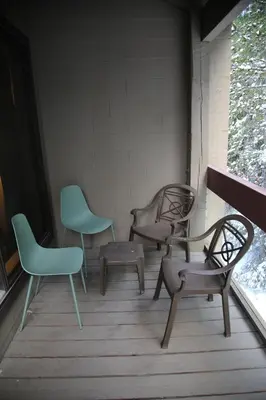 three chairs and a table on a porch at Tantalus Lodge by Elevate Vacations in Whistler