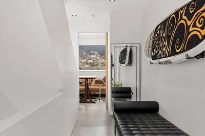 a living room with a black couch and a table at Nest Luxury Modern Lake House in Penticton