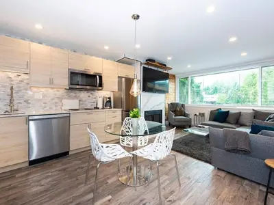 a kitchen and living room with a table and chairs at Whistler Village Center - Newly Renovated Condo in Whistler