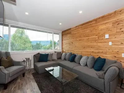 a living room with a couch and a wooden wall at Whistler Village Center - Newly Renovated Condo in Whistler