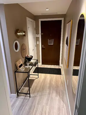 a hallway with a glass table and a door at Century Park Condo Oasis in Edmonton
