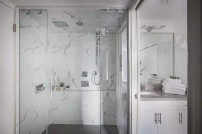 a white bathroom with a shower and a sink at Ski-In-Out, Pool, Hot Tub, Sauna in Whistler