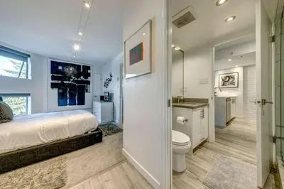 a white bedroom with a bed and a toilet at Ski-In-Out, Pool, Hot Tub, Sauna in Whistler