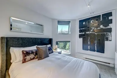 a bedroom with a large white bed and a window at Ski-In-Out, Pool, Hot Tub, Sauna in Whistler