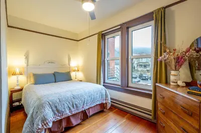 a bedroom with a bed and a large window at Victoria Falls House Inn in Nelson