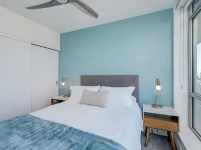a bedroom with a white bed and a window at Escher Escape - Art-filled retreat with work desk by Victoria Prime! in Victoria