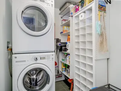 a laundry room with a washer and dryer at Escher Escape - Art-filled retreat with work desk by Victoria Prime! in Victoria