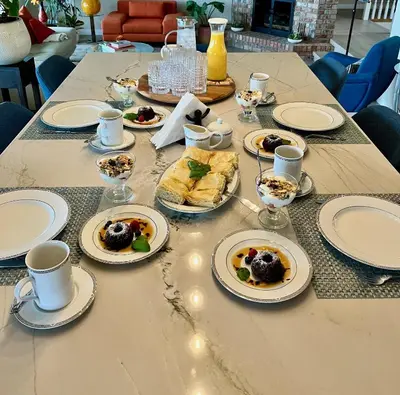 a long table with plates of food on it at Lake and the City Bed and Breakfast in West Kelowna
