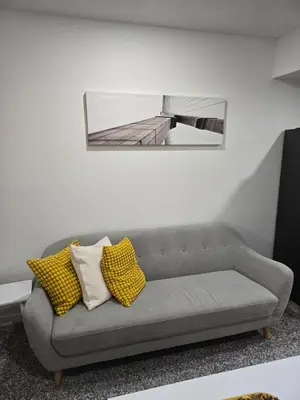 a gray couch in a living room with a mirror at Staycation3179 in Edmonton