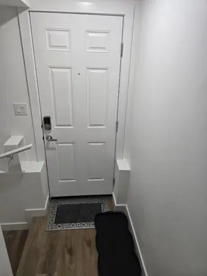 a hallway with a door with a mat in front of it at Staycation3179 in Edmonton