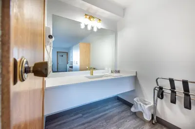 a bathroom with a sink and a mirror at Blue Horse Motel in Beiseker