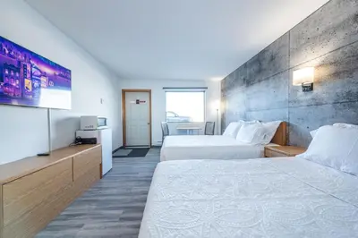 a hotel room with two beds and a tv at Blue Horse Motel in Beiseker