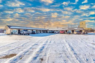 a snow covered parking lot in front of a building at Blue Horse Motel in Beiseker