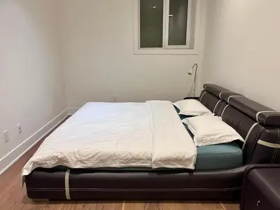 a bed in a room with a black bed frame at Cozy&Private Suite in Vancouver in Vancouver